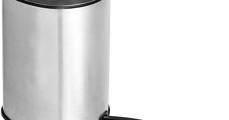 Black Amazon Basics electric coffee grinder with stainless steel bowl filled with coffee beans on a kitchen countertop.