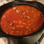 Bowl of pasta fagioli soup with kidney beans, ditalini pasta, carrots, ground turkey, spinach, and herbs in a tomato broth.